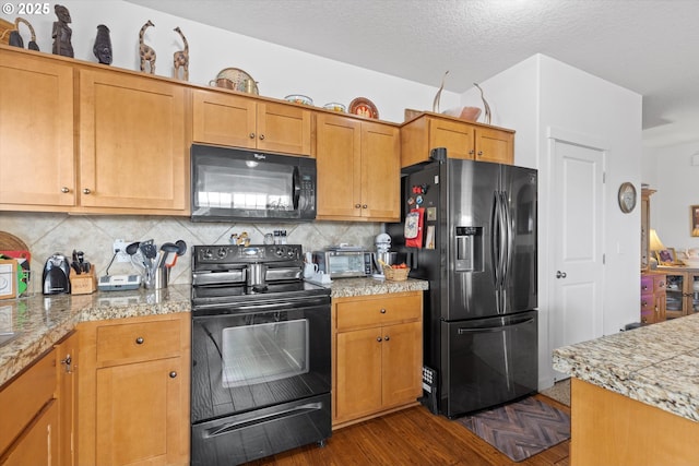 kitchen featuring backsplash, black appliances, dark hardwood / wood-style floors, and a textured ceiling