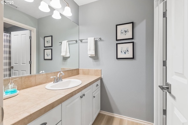 bathroom featuring vanity, hardwood / wood-style flooring, and decorative backsplash