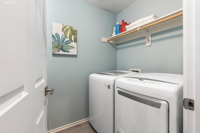 clothes washing area with separate washer and dryer and hardwood / wood-style flooring