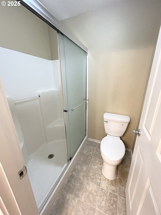 15779 SW Harvester Ln, Sherwood, OR 97140 - full bathroom with toilet, baseboards, a shower stall, and tile patterned floors