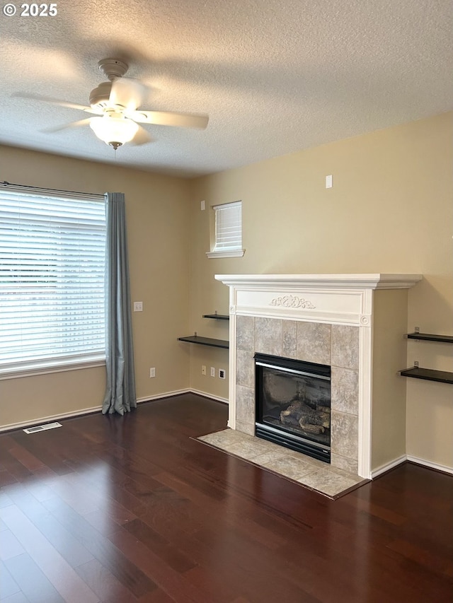 15779 SW Harvester Ln, Sherwood, OR 97140 - unfurnished living room featuring a fireplace, ceiling fan, a textured ceiling, wood finished floors, and baseboards