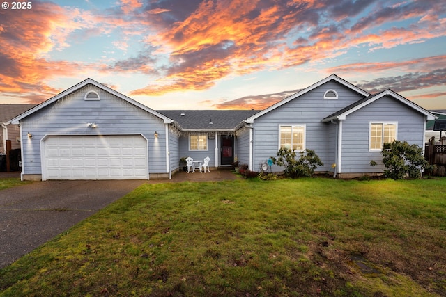 ranch-style house featuring a garage, driveway, and a front lawn