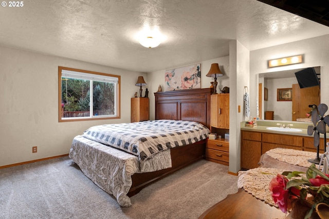 bedroom featuring light carpet, a textured ceiling, baseboards, and a sink