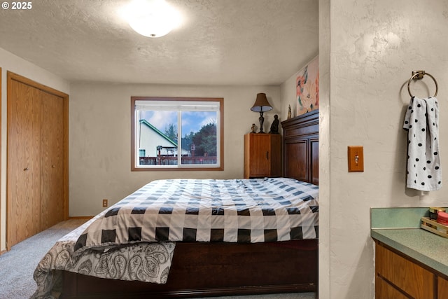 carpeted bedroom featuring a textured ceiling and a textured wall