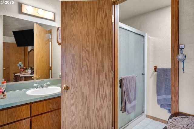 bathroom with a stall shower, vanity, and tile patterned floors