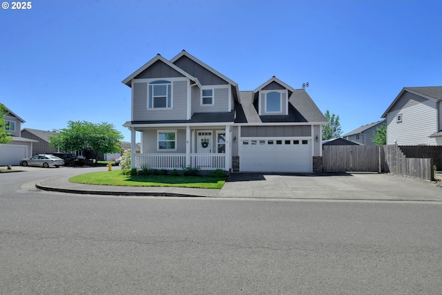 1027 Turtledove Loop, Lebanon, OR 97355 - view of front facade with board and batten siding, stone siding, a porch, driveway, and an attached garage