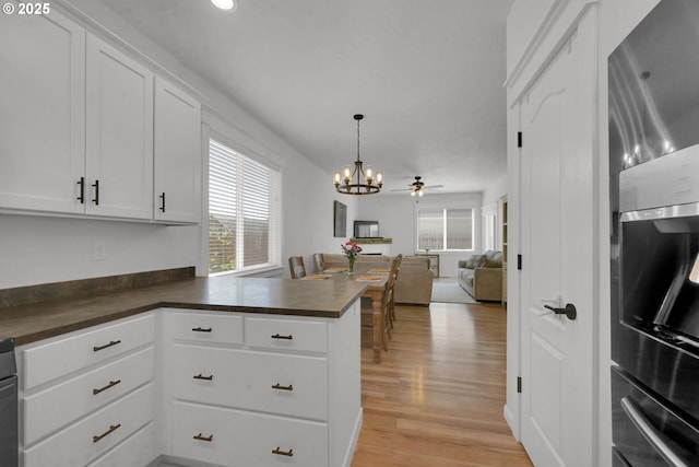 1027 Turtledove Loop, Lebanon, OR 97355 - kitchen featuring stainless steel fridge, dark countertops, plenty of natural light, and open floor plan