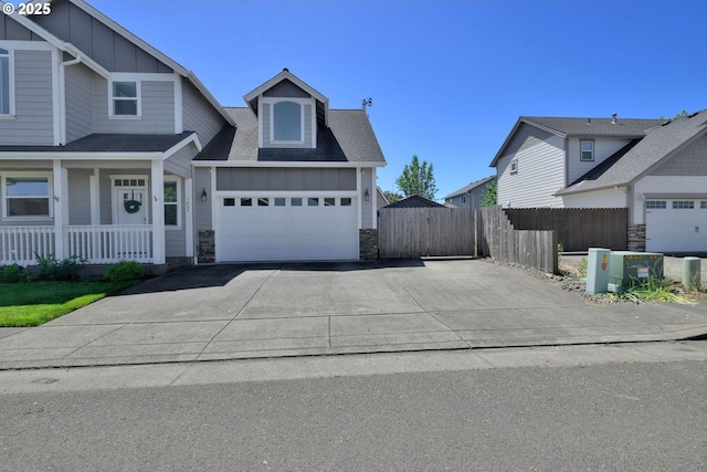 1027 Turtledove Loop, Lebanon, OR 97355 - view of front facade featuring board and batten siding, stone siding, driveway, a porch, and a shingled roof