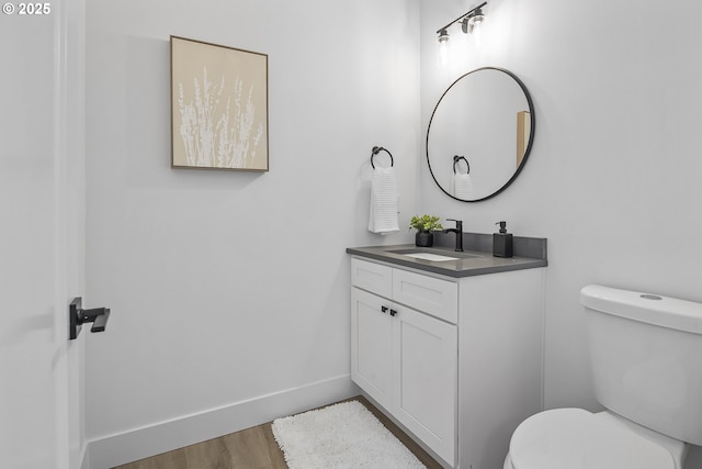 bathroom with vanity, hardwood / wood-style flooring, and toilet