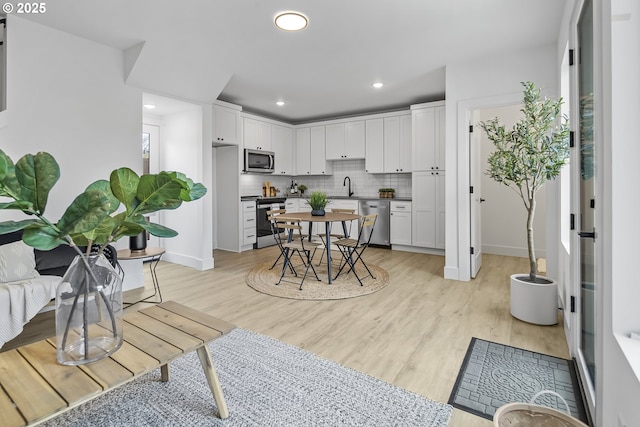 kitchen with white cabinetry, appliances with stainless steel finishes, sink, and tasteful backsplash