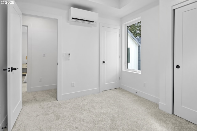 unfurnished bedroom with light colored carpet, a wall unit AC, and a closet