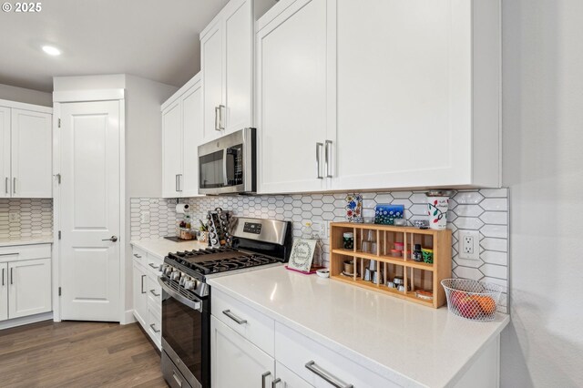 kitchen featuring white cabinetry, appliances with stainless steel finishes, backsplash, and hardwood / wood-style flooring