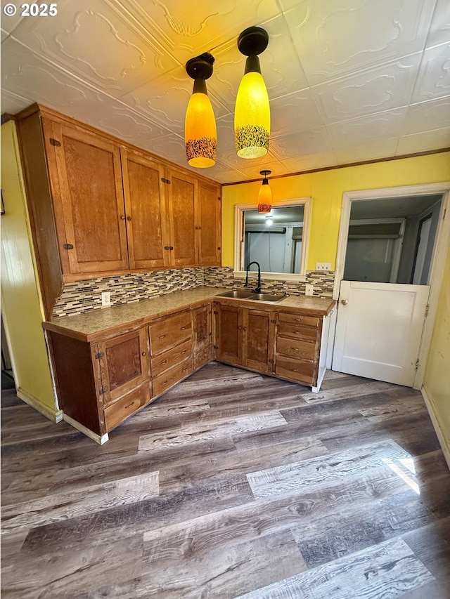 318 SW Brent Dr, John Day, OR 97845 - kitchen with brown cabinets, dark wood-style floors, backsplash, and hanging light fixtures