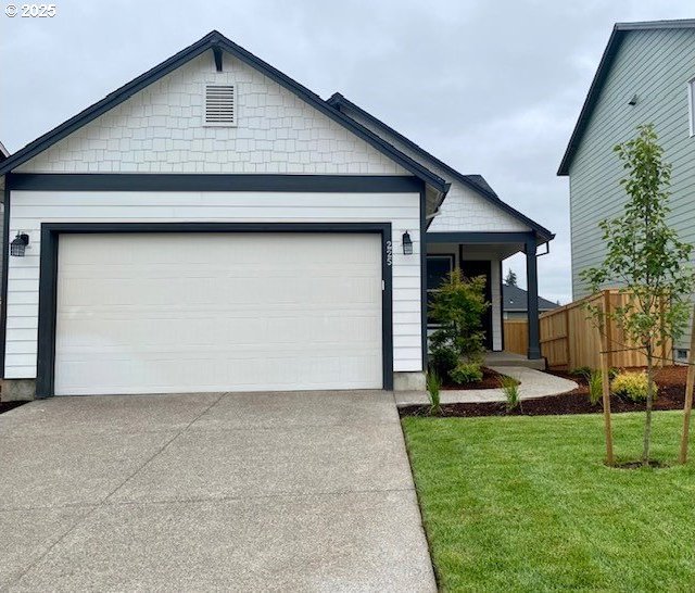 single story home with a garage, driveway, and a front lawn