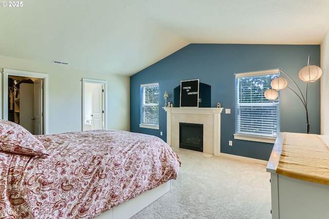 9288 SW Diamond View Way, Beaverton, OR 97007 - bedroom with carpet, vaulted ceiling, a tiled fireplace, a walk in closet, and baseboards