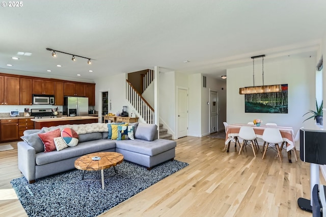 9288 SW Diamond View Way, Beaverton, OR 97007 - living room featuring light wood-style flooring, stairway, and recessed lighting