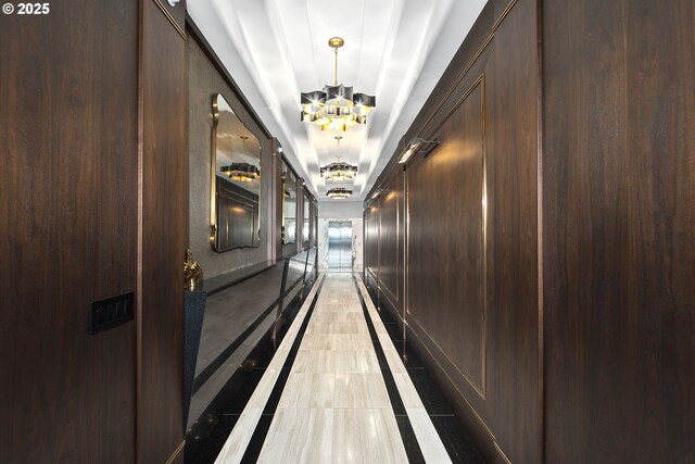 3601 S River Pkwy Unit 3101, Portland, OR 97239 - hallway with inlaid floor details, a chandelier, light tile patterned floors, and a tray ceiling