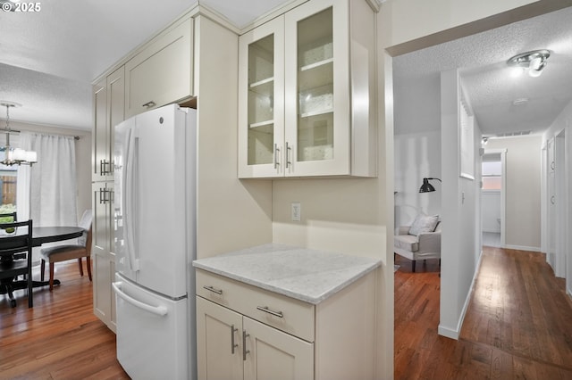 2110 NW Kings Blvd, Corvallis, OR 97330 - kitchen featuring freestanding refrigerator, a textured ceiling, dark wood-style floors, glass insert cabinets, and light stone counters