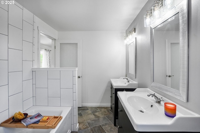 2110 NW Kings Blvd, Corvallis, OR 97330 - full bath with baseboards, a tub to relax in, two vanities, and stone finish flooring