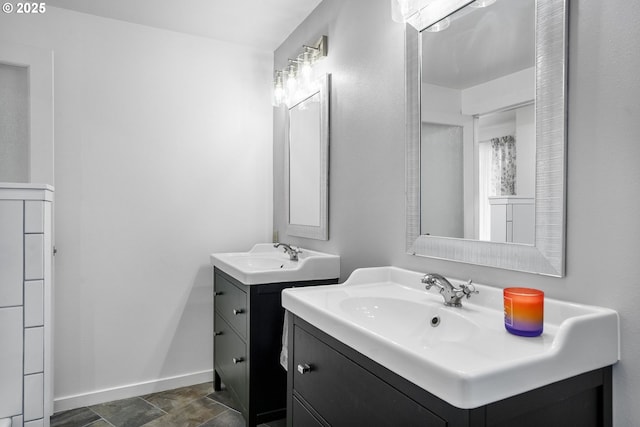 2110 NW Kings Blvd, Corvallis, OR 97330 - bathroom featuring two vanities, baseboards, and stone finish floors