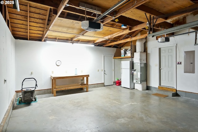 2110 NW Kings Blvd, Corvallis, OR 97330 - garage featuring freestanding refrigerator, a garage door opener, electric panel, and a workshop area