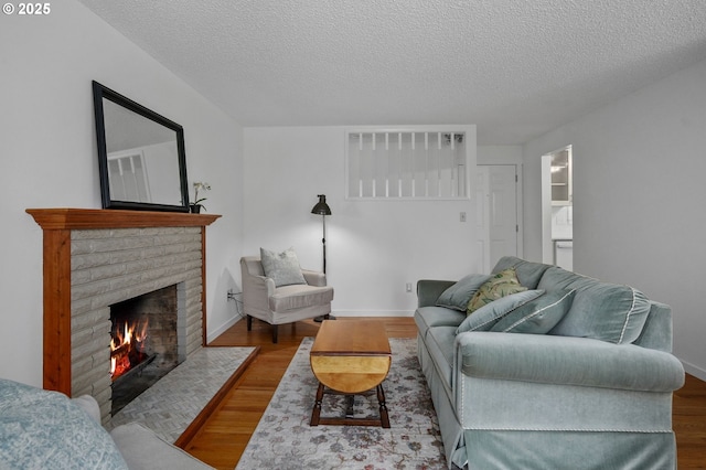 2110 NW Kings Blvd, Corvallis, OR 97330 - living area with a brick fireplace, wood finished floors, a textured ceiling, and baseboards
