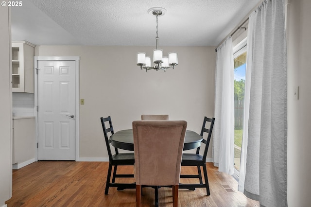 2110 NW Kings Blvd, Corvallis, OR 97330 - dining area featuring wood finished floors, a chandelier, a textured ceiling, and baseboards