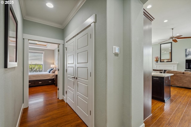 hall with crown molding, dark wood finished floors, recessed lighting, and baseboards