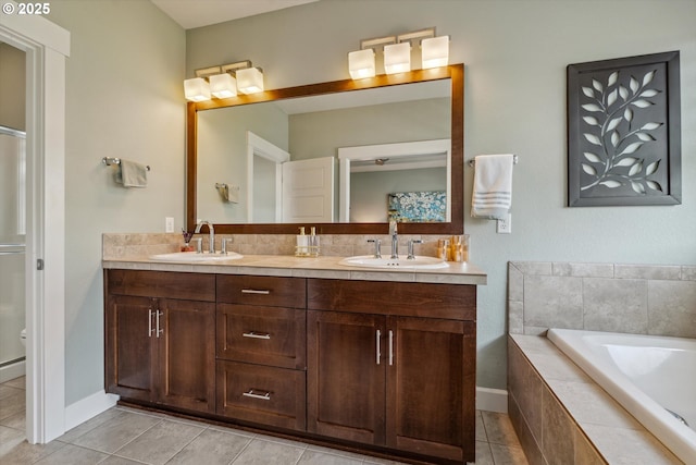 bathroom with tile patterned floors, double vanity, a garden tub, toilet, and baseboards