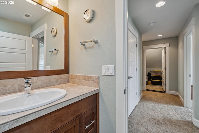 bathroom featuring vanity, recessed lighting, and baseboards