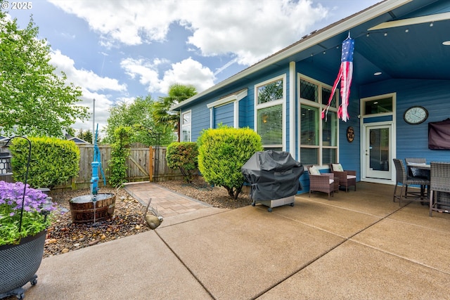 view of patio / terrace featuring grilling area, fence, a gate, and outdoor dining space