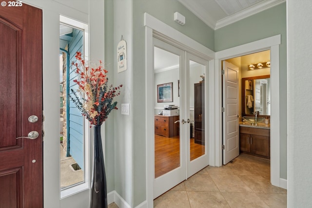 foyer with crown molding, french doors, light tile patterned floors, and baseboards