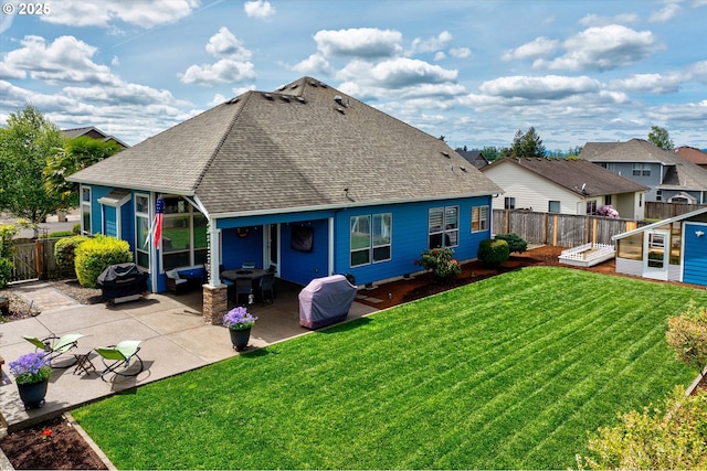 back of house with a shingled roof and a patio