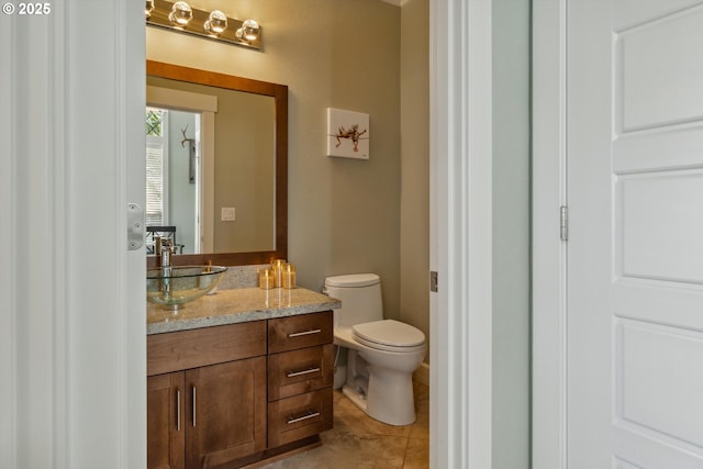 half bath with tile patterned flooring, vanity, and toilet