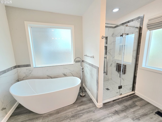 292 Jamie Loop, Roseburg, OR 97471 - bathroom with tile walls, a soaking tub, a stall shower, wood finished floors, and a wainscoted wall