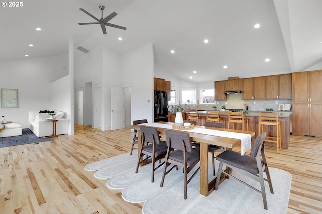 dining space with light wood-style floors, high vaulted ceiling, and recessed lighting