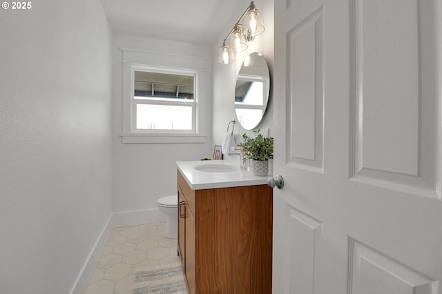 bathroom with baseboards, tile patterned floors, toilet, and vanity