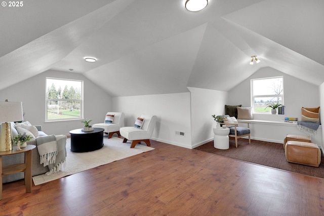 office space featuring baseboards, wood finished floors, vaulted ceiling, and visible vents