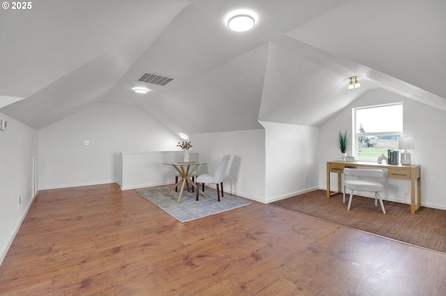 bonus room featuring baseboards, visible vents, wood finished floors, and vaulted ceiling