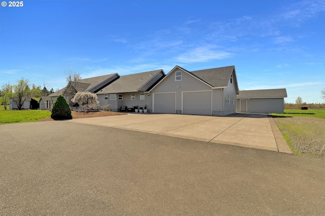 ranch-style home featuring roof with shingles, an attached garage, driveway, and a front lawn