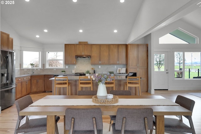 kitchen featuring recessed lighting, a sink, lofted ceiling, and fridge with ice dispenser