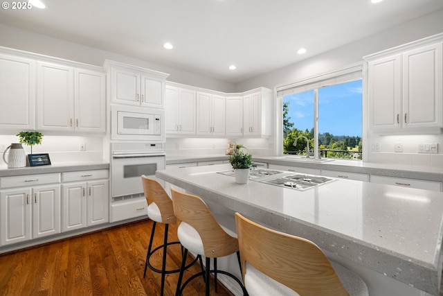 2360 Michael, West Linn, OR 97068 - kitchen featuring white appliances, a sink, a kitchen bar, white cabinets, and recessed lighting