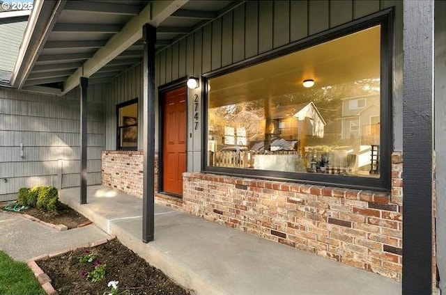 property entrance featuring brick siding and board and batten siding