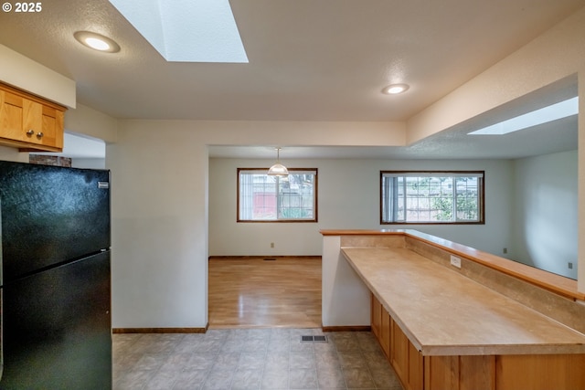 1949 Waln Creek Dr, Salem, OR 97306 - kitchen featuring freestanding refrigerator, a skylight, baseboards, plenty of natural light, and recessed lighting