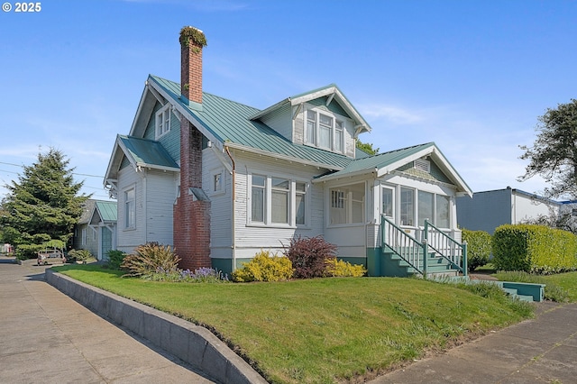 701 Main Ave, Tillamook, OR 97141 - view of home's exterior featuring a chimney, metal roof, a yard, entry steps, and a standing seam roof
