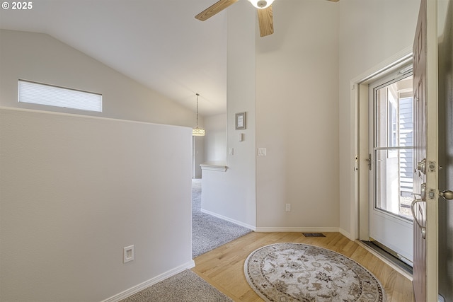 entrance foyer featuring light wood-type flooring, baseboards, visible vents, and vaulted ceiling