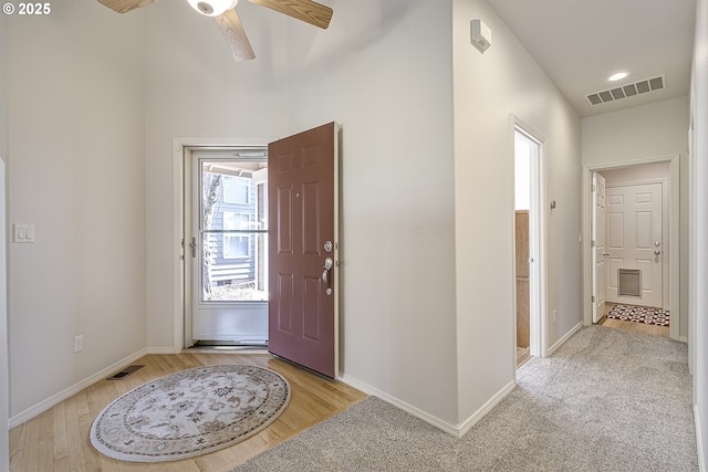 foyer with visible vents, baseboards, light wood-style floors, and a ceiling fan