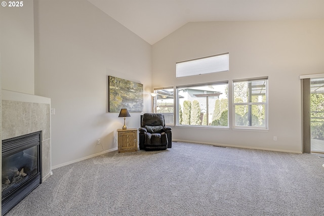 sitting room featuring visible vents, high vaulted ceiling, a glass covered fireplace, and carpet flooring