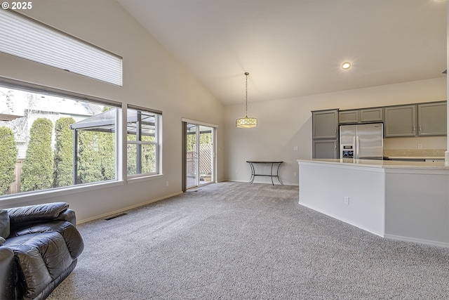 unfurnished living room with visible vents, baseboards, light colored carpet, recessed lighting, and high vaulted ceiling