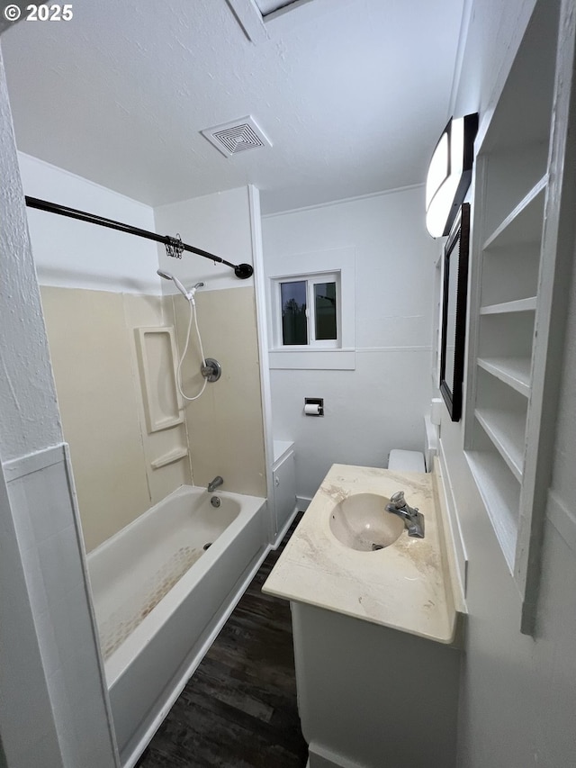 full bathroom with vanity, tub / shower combination, hardwood / wood-style floors, and toilet